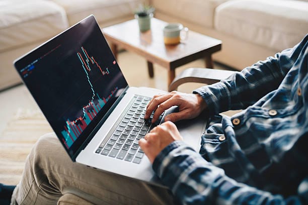 Investor monitoring stock market charts, representing the fees, taxes, and time costs of active trading